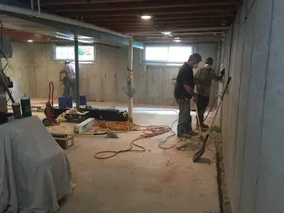 Crew clearing wet materials from an unfinished basement in west St. Louis County