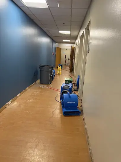 Air movers lined up along a hallway floor drying a west St. Louis County office after a leak