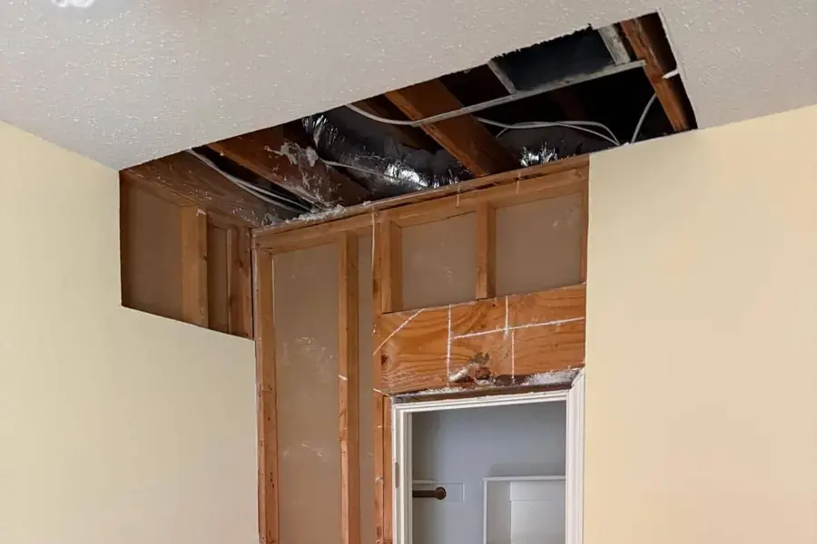Ceiling drywall opened up to dry the framing after a leak from the floor above
